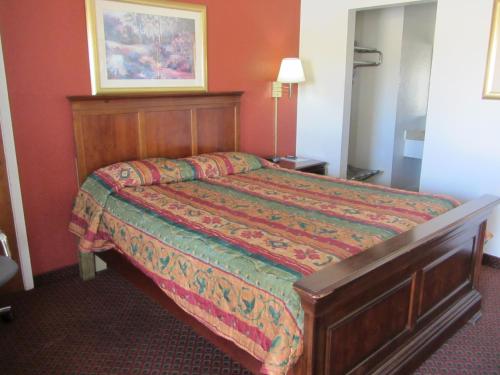 a bedroom with a bed in a red room at American Star Inn - Abilene in Abilene