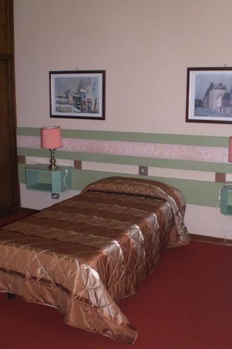 a bedroom with a bed with a striped wall at Hotel La Meridiana in Brisighella