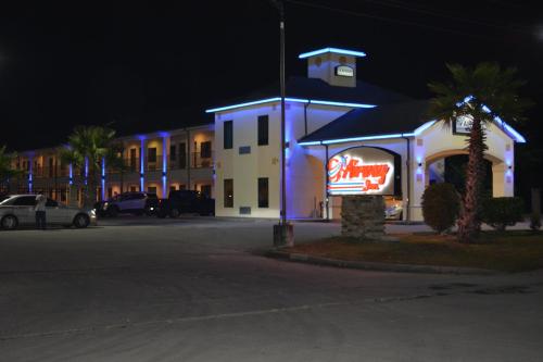 a building with a neon sign in front of it at Airway Inn - IAH Airport in Houston