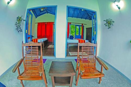 two chairs and a wooden table in a room at Seth Villa by Magampura Resorts in Tangalle
