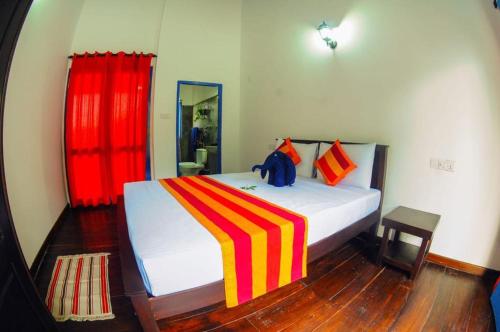 a bedroom with a large bed with a red curtain at Seth Villa by Magampura Resorts in Tangalle