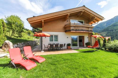 a house with a gazebo and chairs in the yard at Appartementhaus Casamarai in Saalbach Hinterglemm
