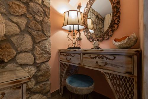 a dressing table with a lamp and a mirror at MARIA'S BOUTIQUE Rooms in Korinthos