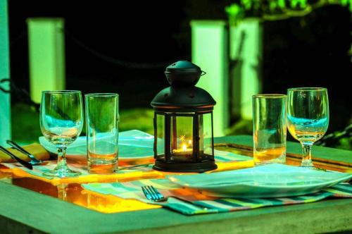 a table with wine glasses and a lantern on it at Seth Villa by Magampura Resorts in Tangalle