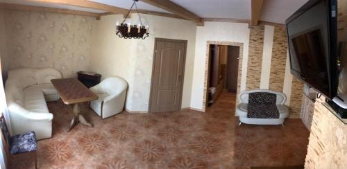 a living room with white furniture and a flat screen tv at Котедж Relax Yaremche in Yaremche