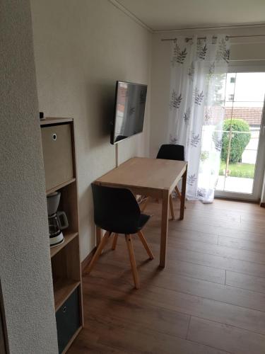 een kamer met een tafel en twee stoelen en een televisie bij FEWO Jürgen + Conny in Babenhausen