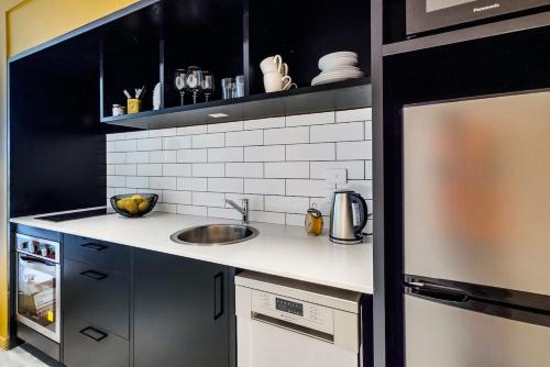 a kitchen with a sink and a counter top at Roomie Apartment Hotel in Auckland