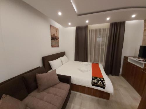 a hotel room with a bed and a couch at AMI apartman Kopaonik in Kopaonik