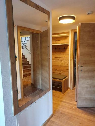 a hallway with a mirror and a staircase in a house at Appartementhaus AURUM - Summercard included in Zell am See