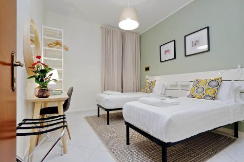 a hotel room with two beds and a table at Casa Santa Sofia in Rome