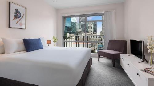 ein Hotelzimmer mit einem großen Bett und einem Fenster in der Unterkunft Auckland Harbour Suites in Auckland
