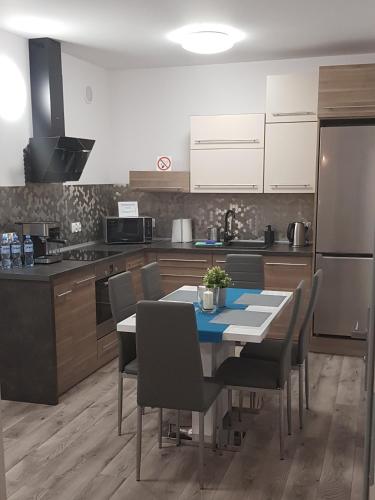 una cucina con tavolo, sedie e frigorifero di Apartament RODZINNY Wałowa Wejherowo a Wejherowo