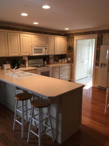 a kitchen with a island with two bar stools at Downtown abode in the heart of the Bourbon Trail in Lebanon