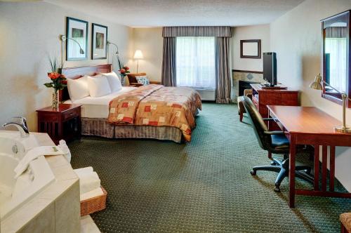 a hotel room with a bed and a desk at Lakeview Inns & Suites - Slave Lake in Slave Lake