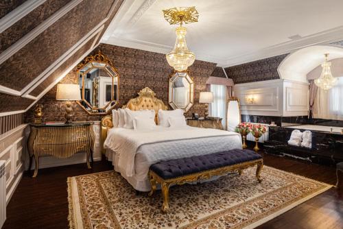 a bedroom with a large bed and a chandelier at Hotel Colline de France in Gramado