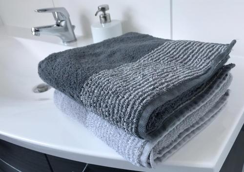 Una toalla gris sobre un lavabo. en Ferienwohnungen Scheuring 1.OG, en Volkach