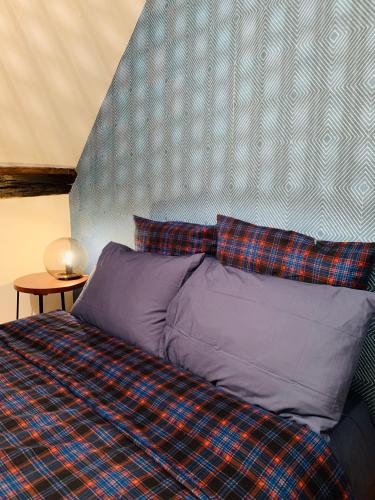 - un lit avec une couverture à tresses et 2 oreillers dans l'établissement La maison de Nina, à Sens