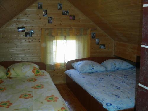 a bedroom with two beds in a log cabin at Apartments Marevic in Kupres