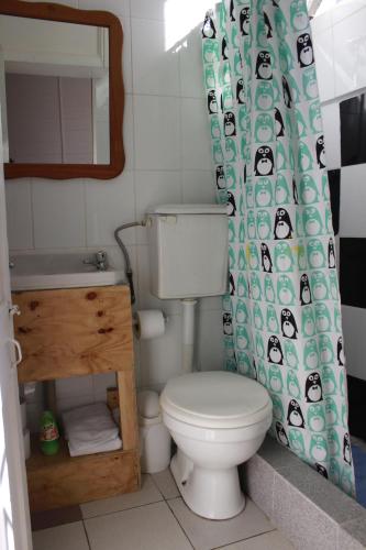 a bathroom with a toilet and a shower curtain at Casa Volante Hostal in Valparaíso