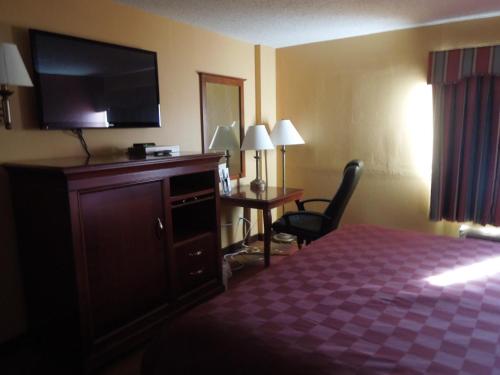 a hotel room with a bed and a flat screen tv at Ramada by Wyndham East Orange in East Orange