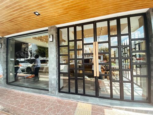 a store front with large glass windows and a man standing inside at YAKTHAI POSHTEL in Bangkok