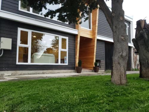 a window on a house with a couch in a yard at Trotamundos in Puerto Natales