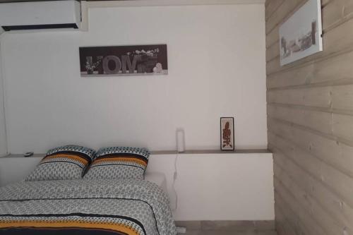a bedroom with a bed and a picture on the wall at F2 ZEN & GREEN - PISCINE et CONFORT in Baie-Mahault