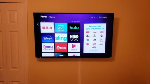 a tv on a wall with a bunch of websites at B Private Bedroom in Orlando