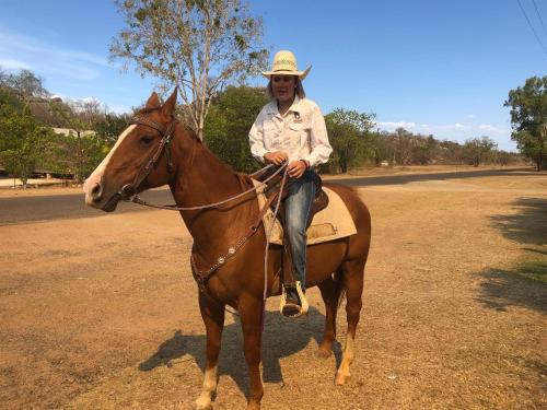 un hombre con un sombrero de vaquero montando un caballo en Chillagoe Cockatoo Hotel Motel, en Chillagoe
