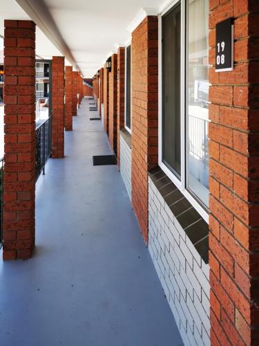 an empty hallway of a brick building with a sign on it at Littomore Suites Bathurst in Bathurst