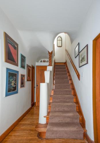 a staircase in a home with white walls and wood floors at Inn on La Loma Plaza in Taos