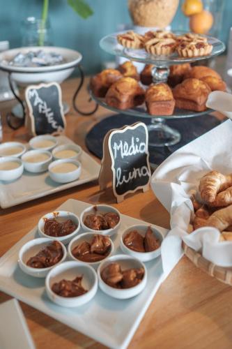 a table topped with trays of pastries and desserts at Posada Plaza Mayor in Colonia del Sacramento