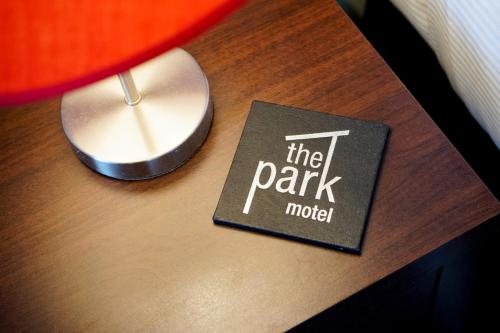 a book on top of a table next to a lamp at The Park Motel in Hawera