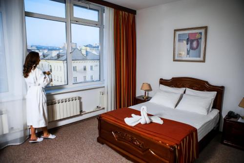 a woman standing in a hotel room looking out the window at Siberia Hotel in Ulan-Ude