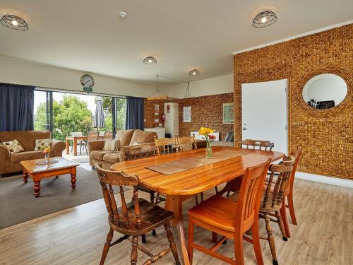 cocina y sala de estar con mesa de madera y sillas en Barnacle Bills en Kaikoura