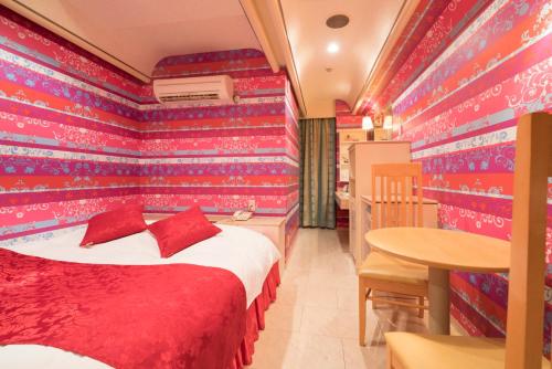 a room with a bed and a table in it at Hotel Route One in Osaka