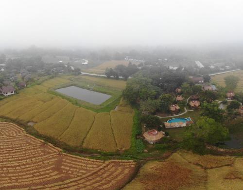an aerial view of a farm with a lake in a field at The Countryside Pai in Pai