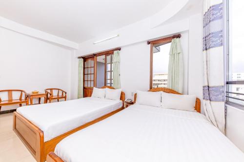 two beds in a room with a window at Minh Cat Hotel in Nha Trang