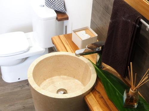a bathroom with a toilet with a wooden seat at Fare noanoa in Mariuti