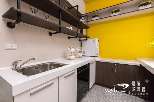 冬山鄉的住宿－非住不可，厨房设有水槽和黄色的墙壁