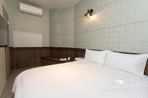 ein Schlafzimmer mit einem großen weißen Bett in einem Zimmer in der Unterkunft FDBK Homestay in Dongshan