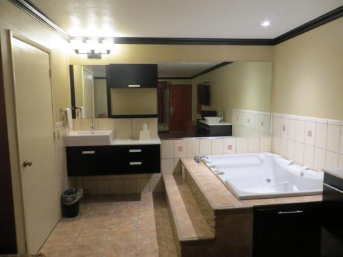 a large bathroom with a tub and a sink at Economy Inn LAX Inglewood in Inglewood