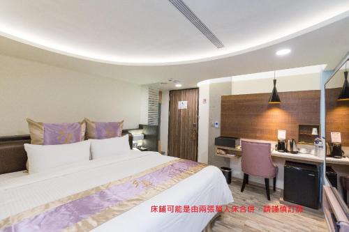 a hotel room with a large bed and a desk at 衿后禾居民生館 Good Hotel Minsheng in Kaohsiung