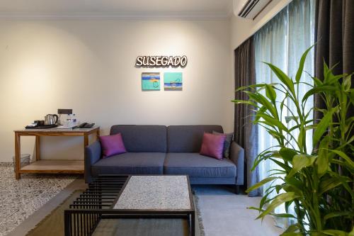 a living room with a blue couch and a table at Regenta Inn Palacio De Goa, Panjim in Panaji