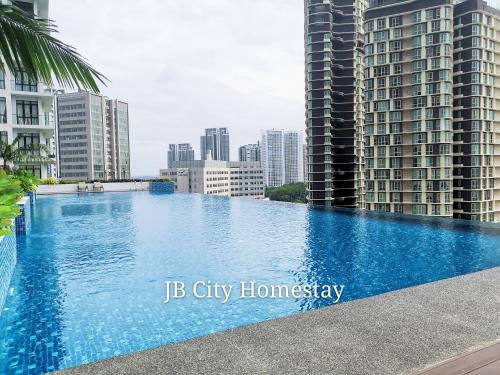 a large swimming pool in a city with tall buildings at D'Pristine Suites by JBcity Home in Nusajaya