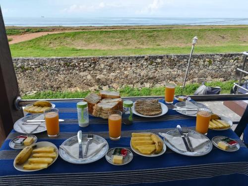 una mesa azul cubierta con platos de comida y bebida en Rampart View Guesthouse, en Galle