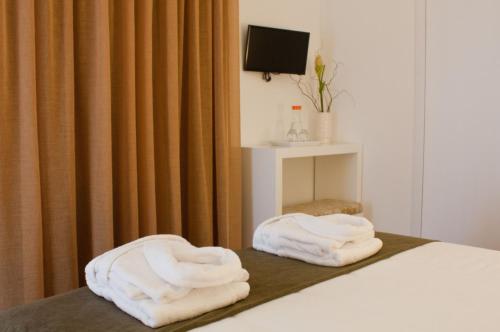 two towels sitting on top of a bed at Quinta Da Mouta in Vieira do Minho
