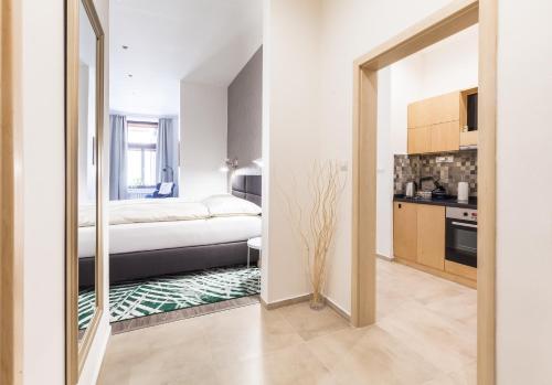 Il comprend une petite chambre avec un lit et une cuisine. dans l'établissement Bolle Apartments , historical centre, à Košice