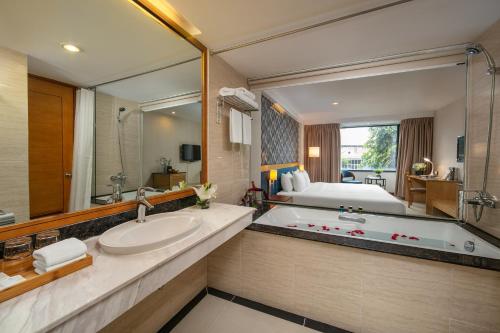 ハノイにあるラ カーサ ハノイ ホテルのバスルーム(大きな鏡、バスタブ、ベッド付)
