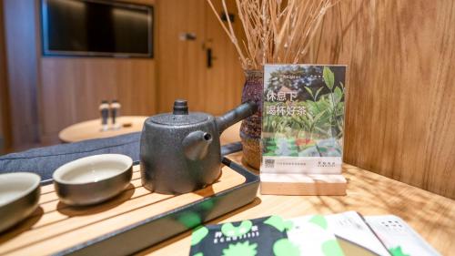a bathroom counter with a tea kettle and a book at WeLight Hotel in Beijing